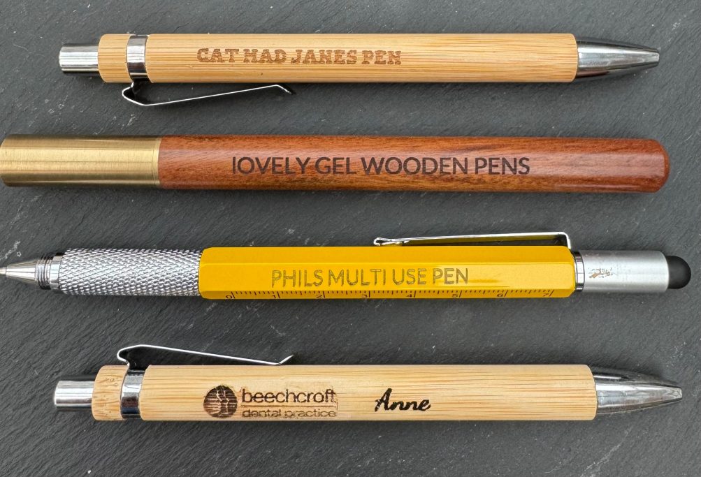 Four pens with various designs and engravings on wooden and metallic bodies.